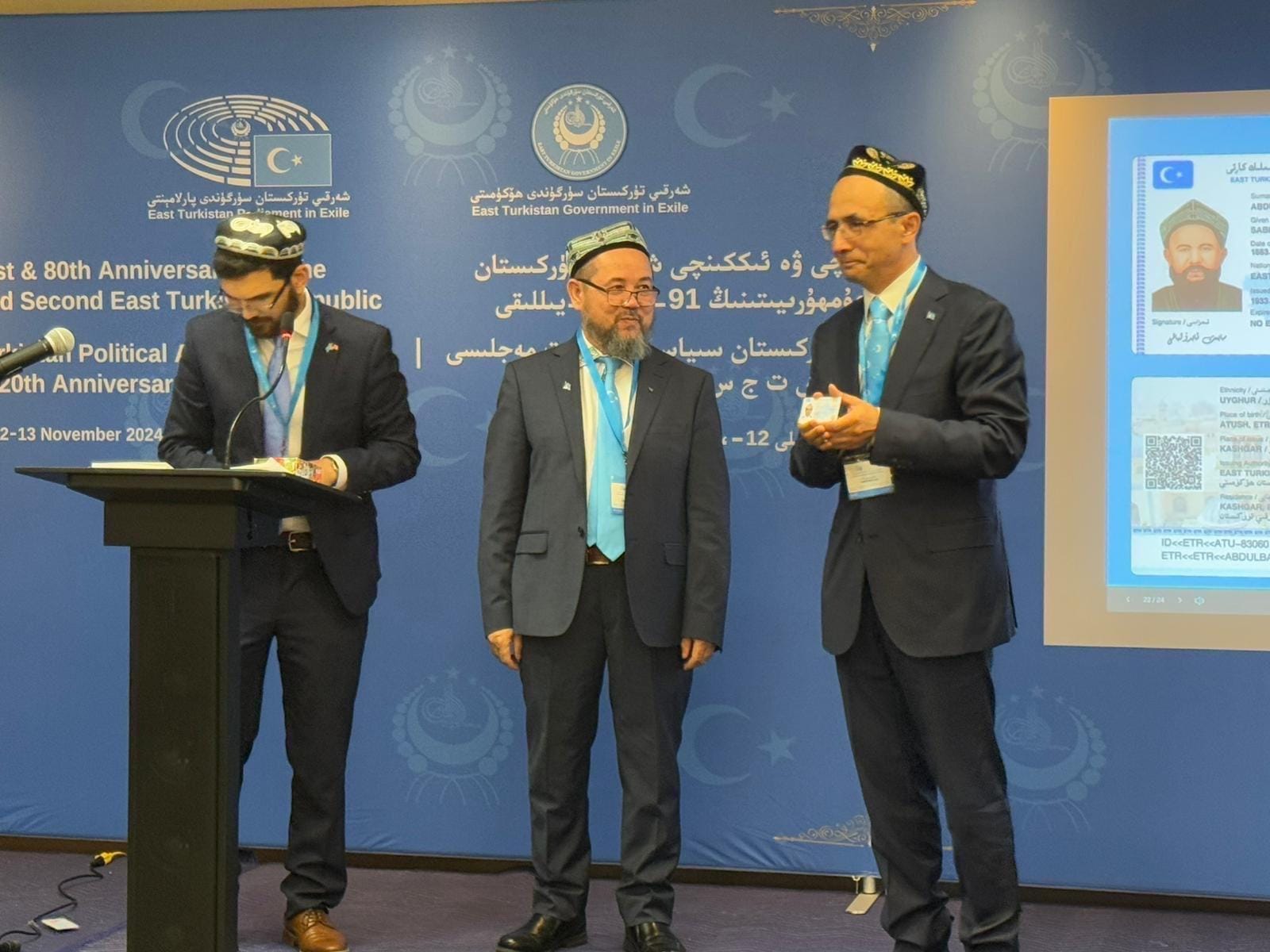 Three representatives on stage at the East Turkistan Government-in-Exile conference.